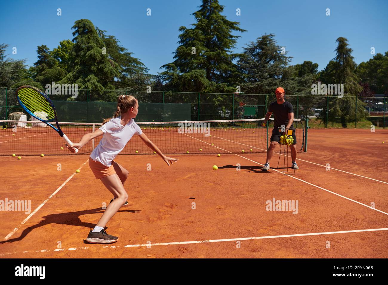 A professional tennis player and her coach training on a sunny day at