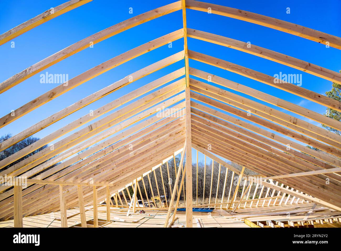 Using wooden frame trusses to support beams for construction of roof