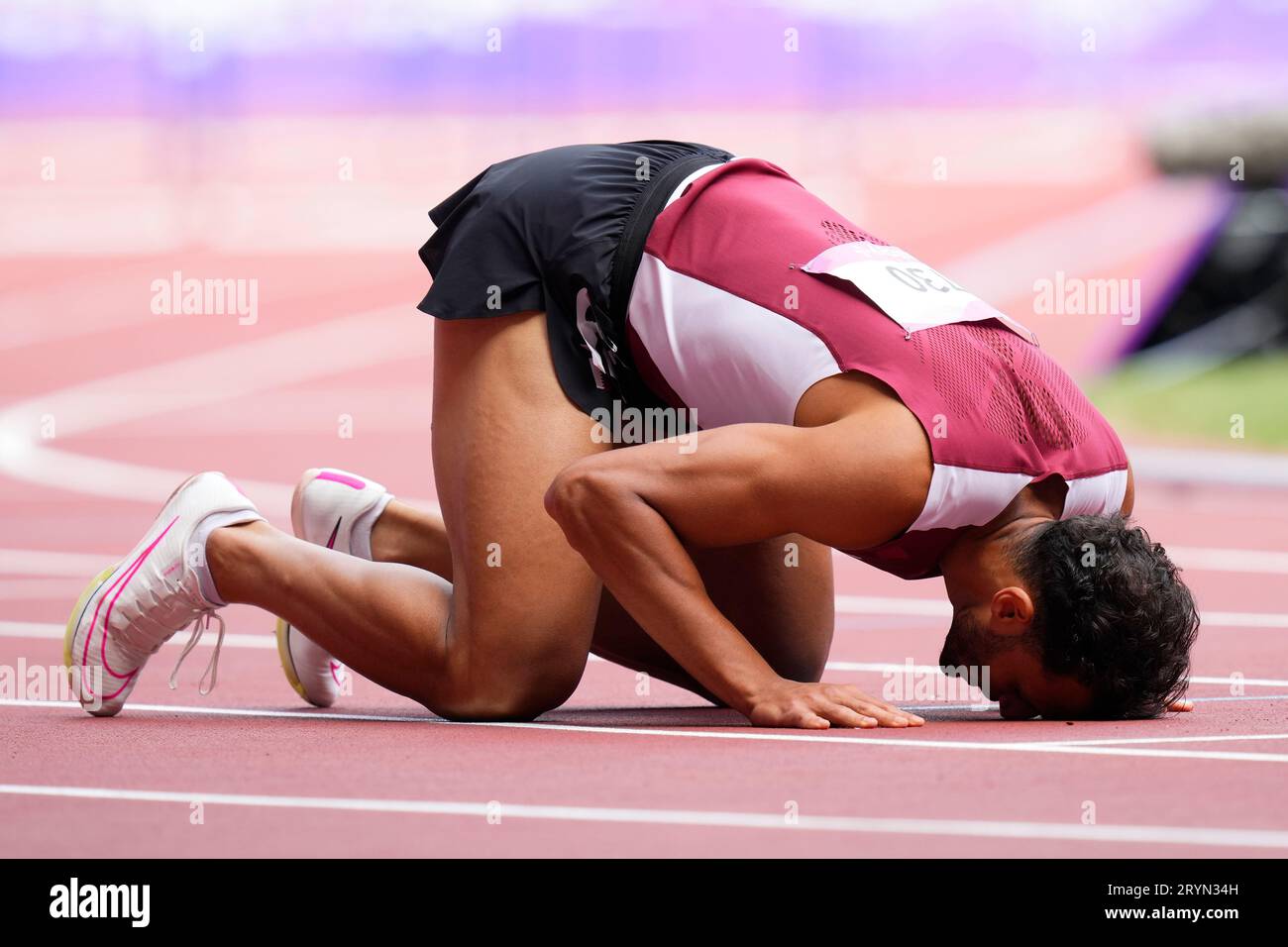 Qatar's Bassem Hemeida, right, reacts after competing in the men's 400