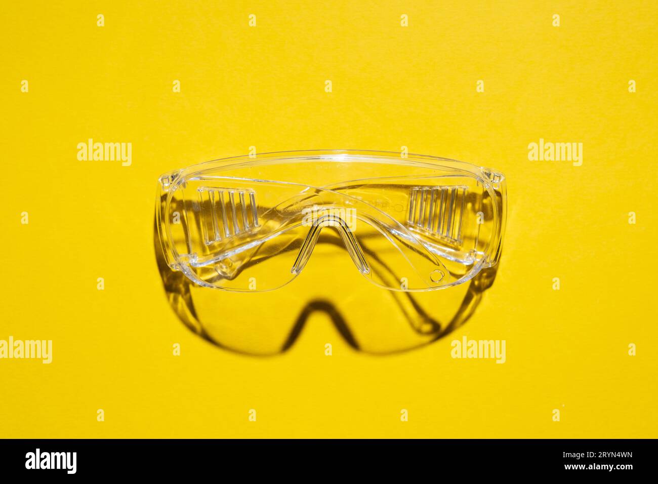 Top view of plastic safety goggles against a yellow background Stock Photo