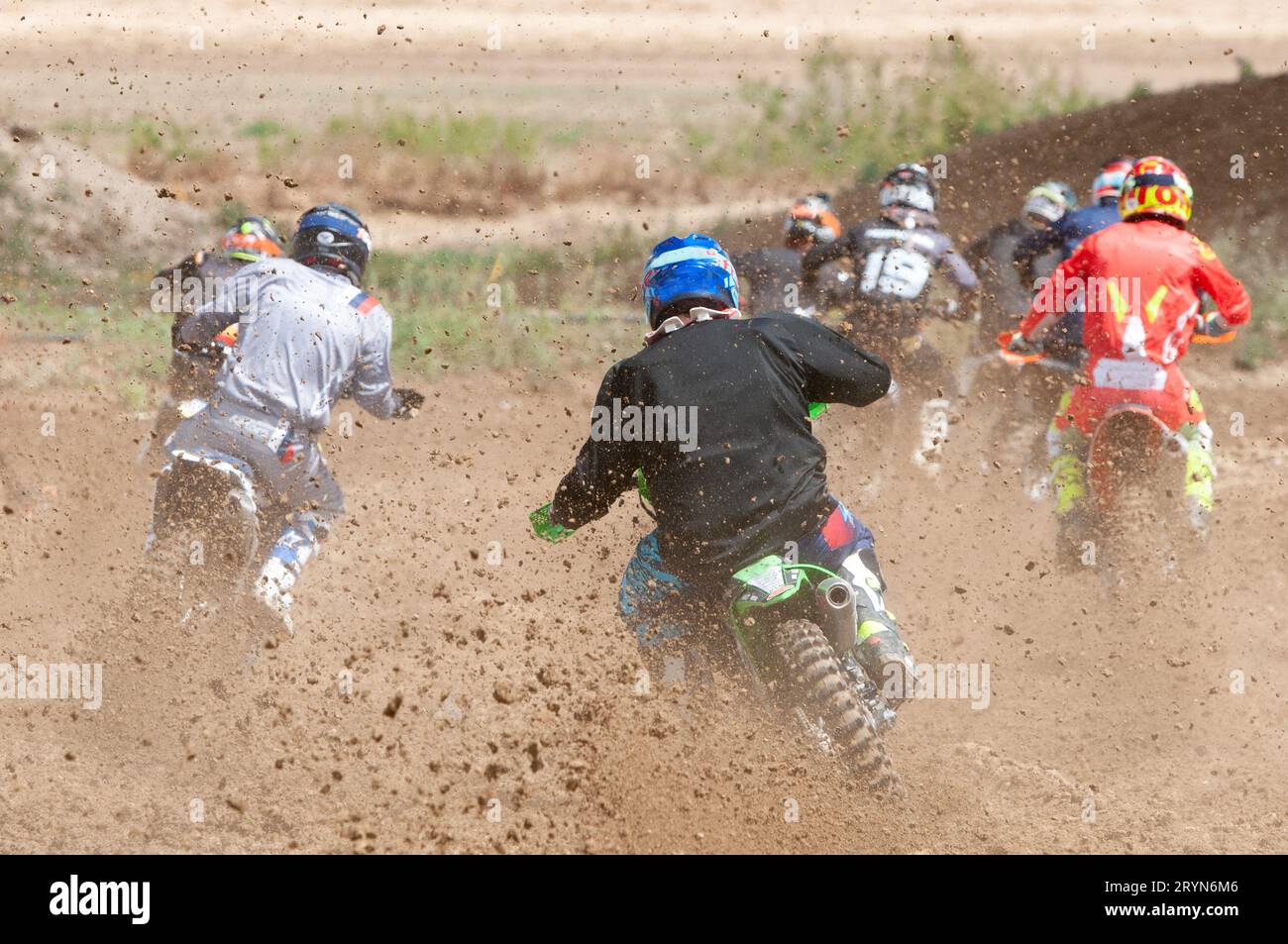 Unrecognized athletes riding a sports motorbike racing fast on a motocross track field. Challenge and competition Stock Photo