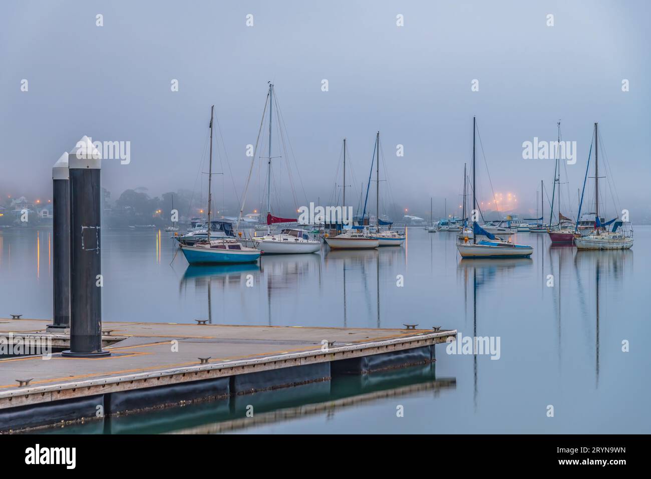 Foggy Sunrise with boats on Brisbane Water at Koolewong and Tascott on the Central Coast, NSW, Australia. Stock Photo