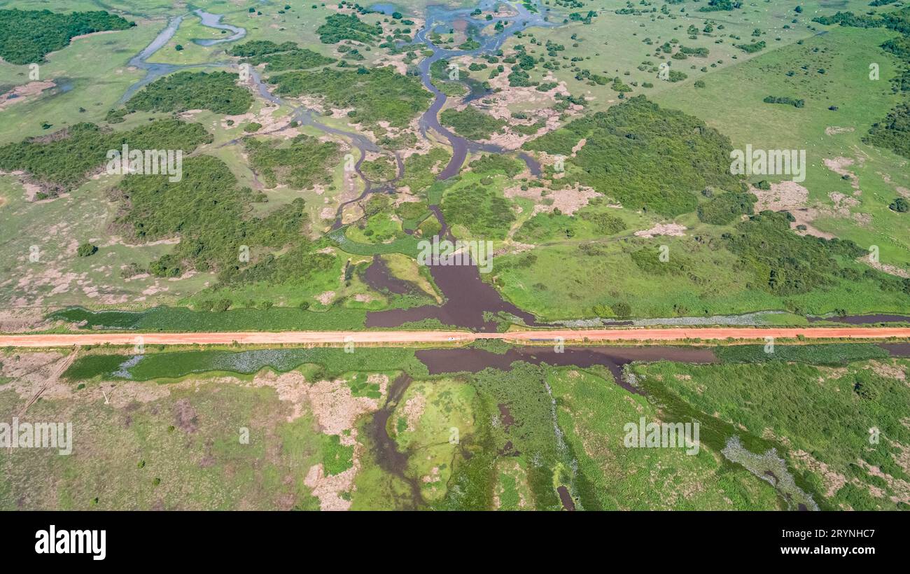 Aerial view of Transpantaneira dirt road crossing a lagoon over a small bridge in the typical landsc Stock Photo