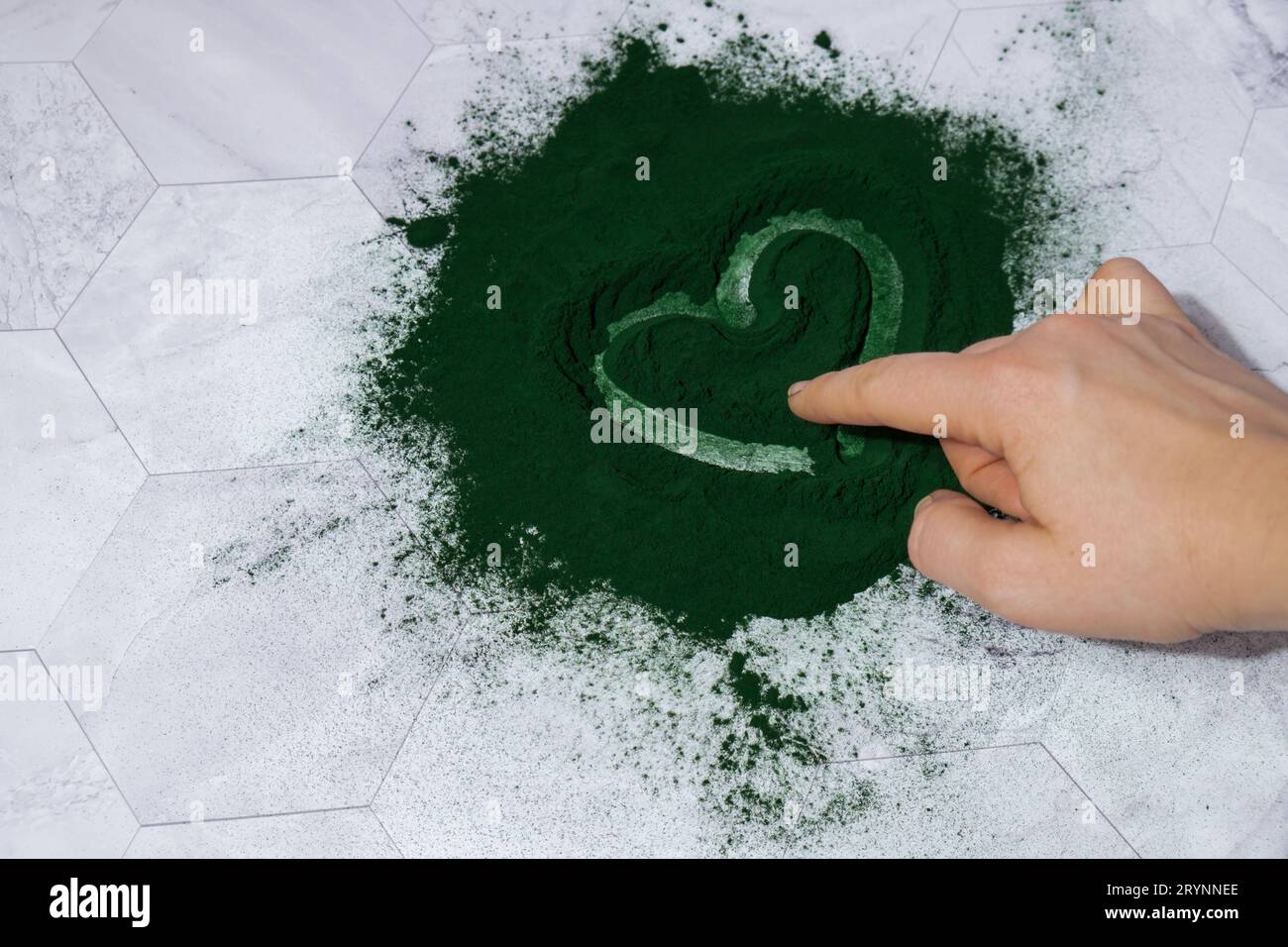 Female hand draw heart on Bluegreen algae Chlorella and spirulina