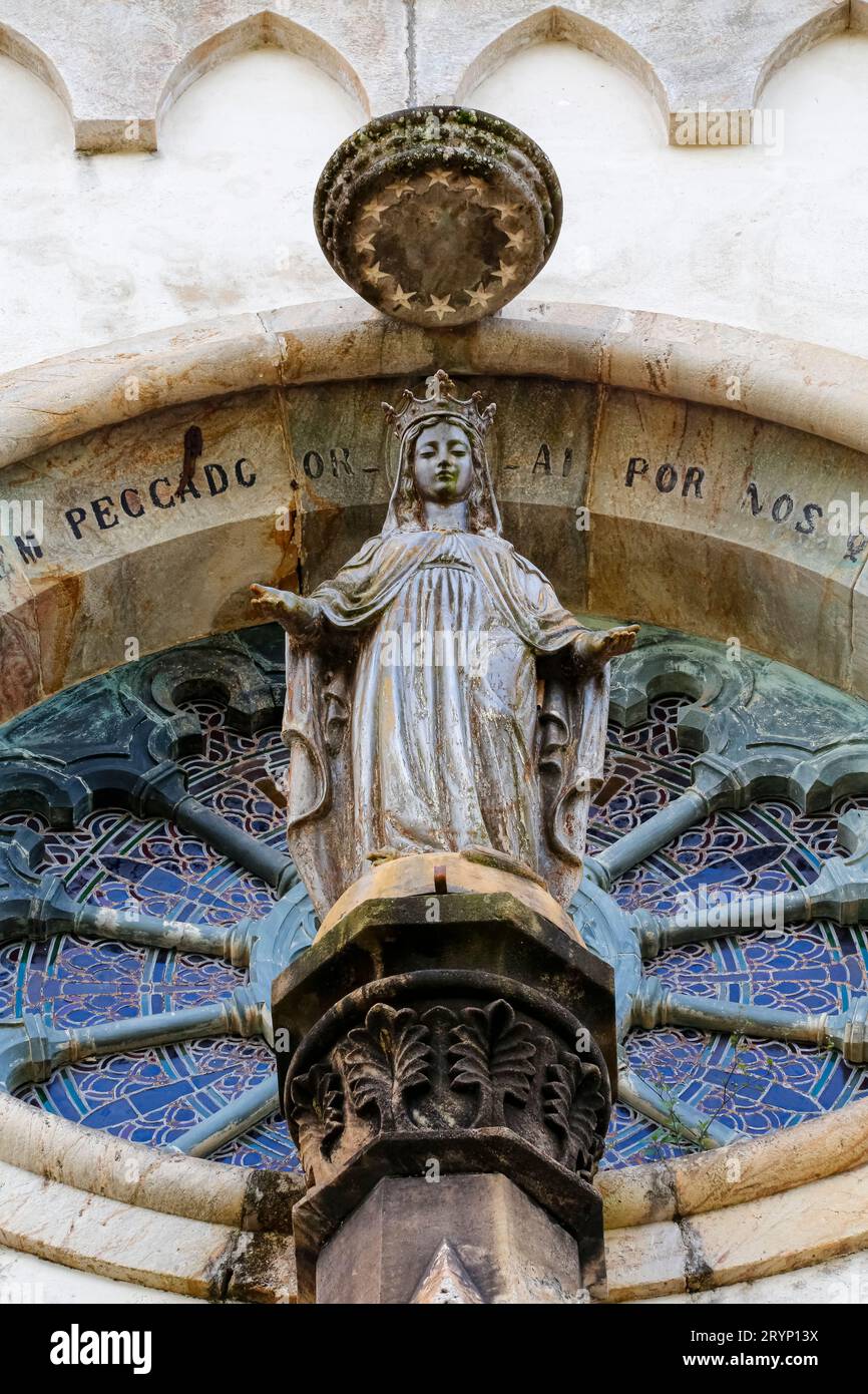Low angle shot of a round church window with a saint sculpture Sanctuary CaraÃ§a, Minas Gerais, Brazi Stock Photo
