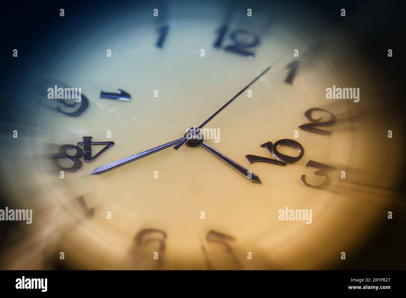 Wristwatch dial with blue hands and crumbling numbers and motion blur effect. Macro photography. Concept of the passage of time, aging Stock Photo