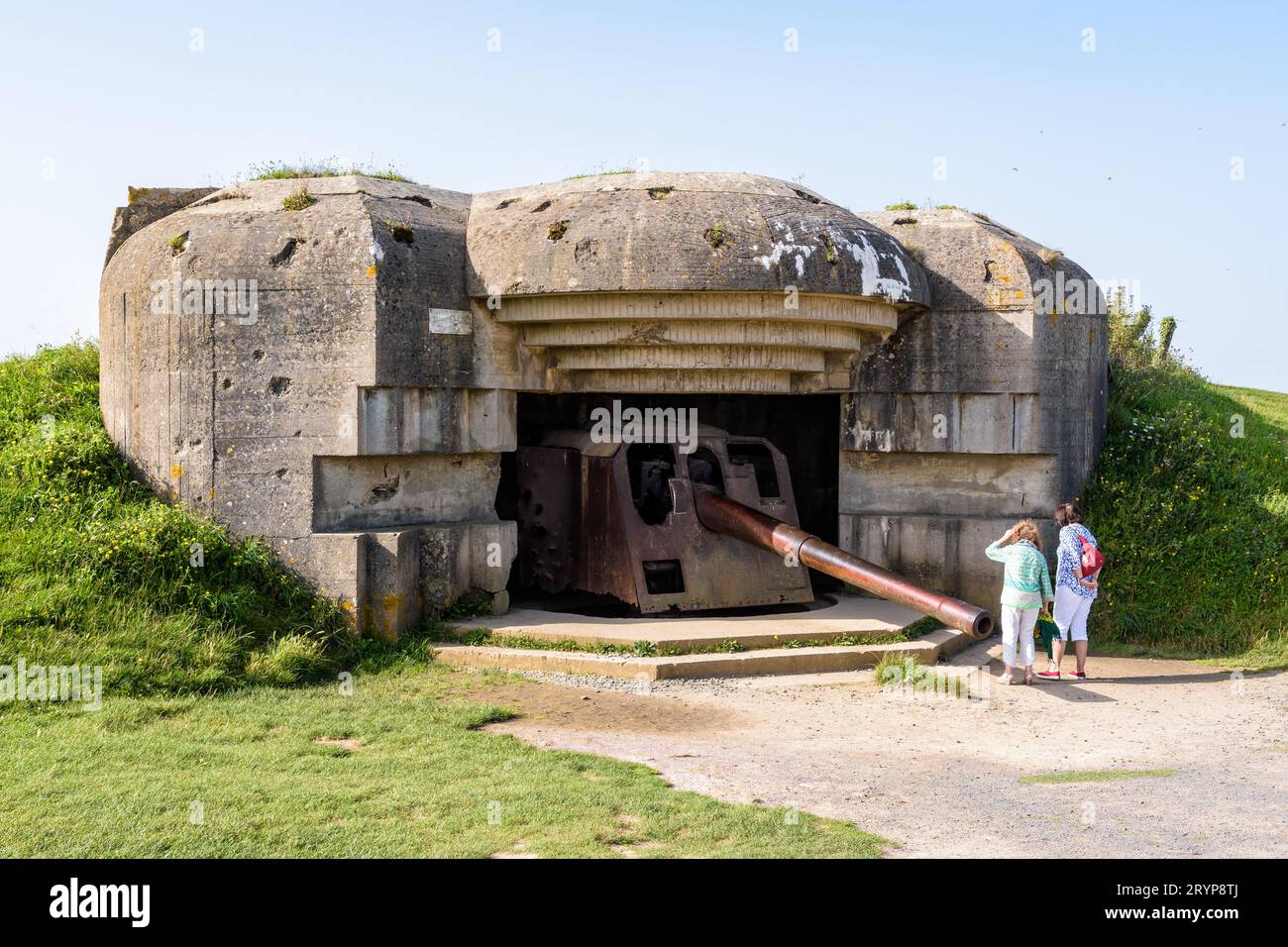 Tourists observe the 150 mm gun in a bunker in the Longues-sur-Mer ...