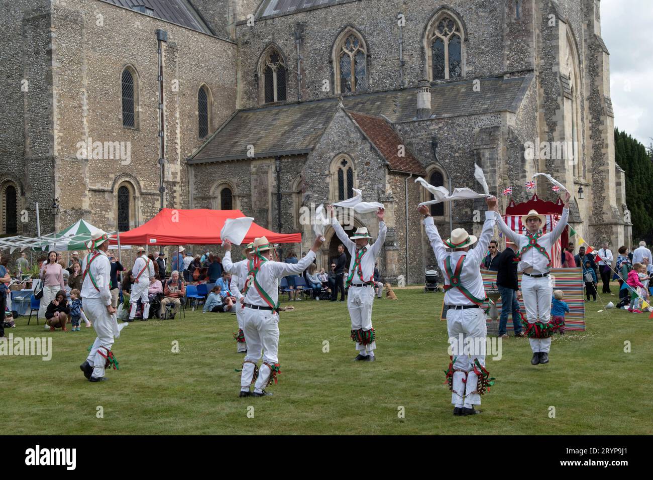 The Hospital of St Cross and Almshouse of Noble Poverty annual summer fete that has taken place for over 150 years. Morris dancing in the background the Church of St Cross a private chapel of the Hospital of St Cross. About 2,000 people attended in 2022. Winchester, Hampshire, England 25th June 2022.  2020s UK HOMER SYKES Stock Photo