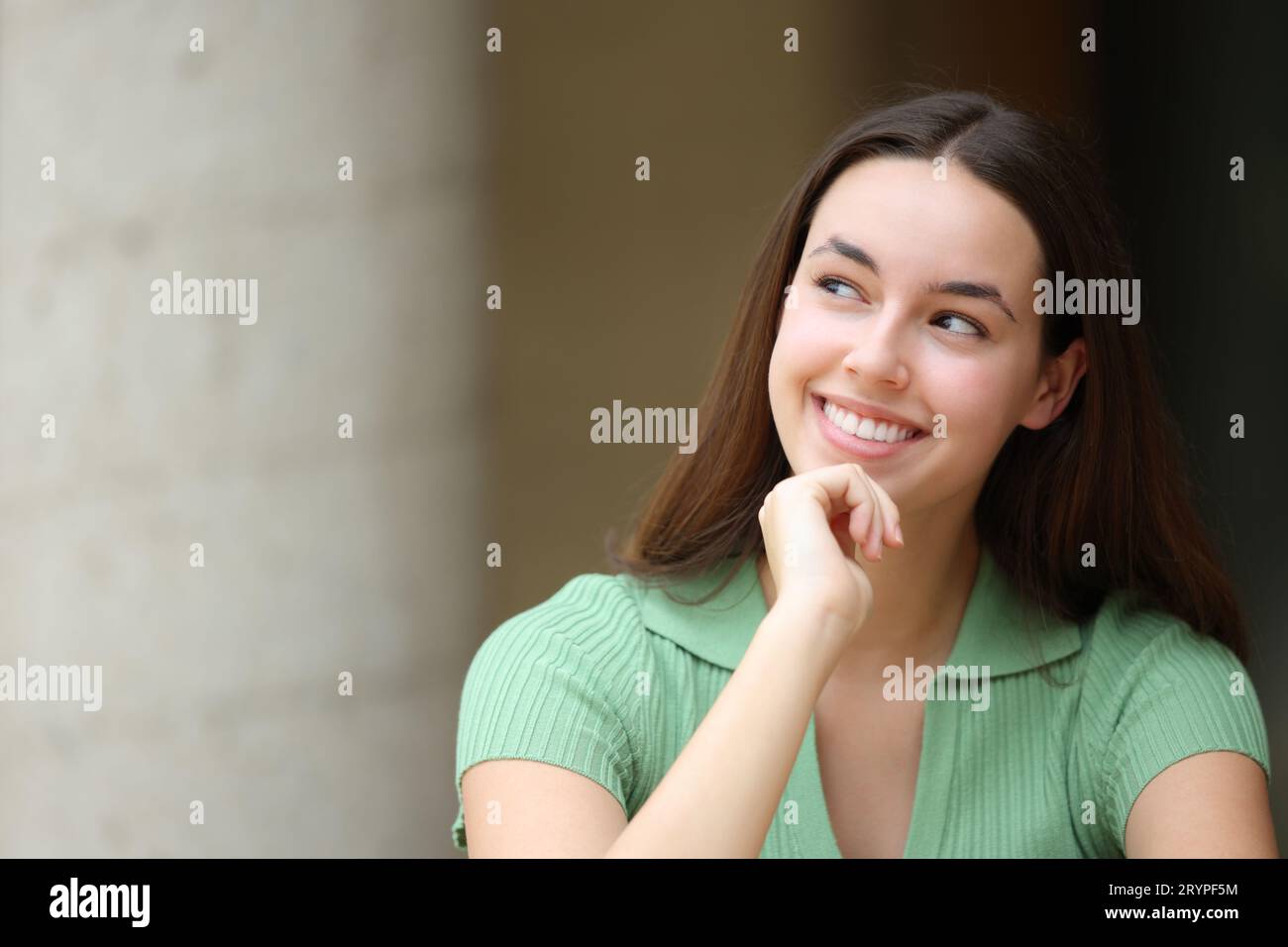 Happy woman in the street thinking looking at side Stock Photo