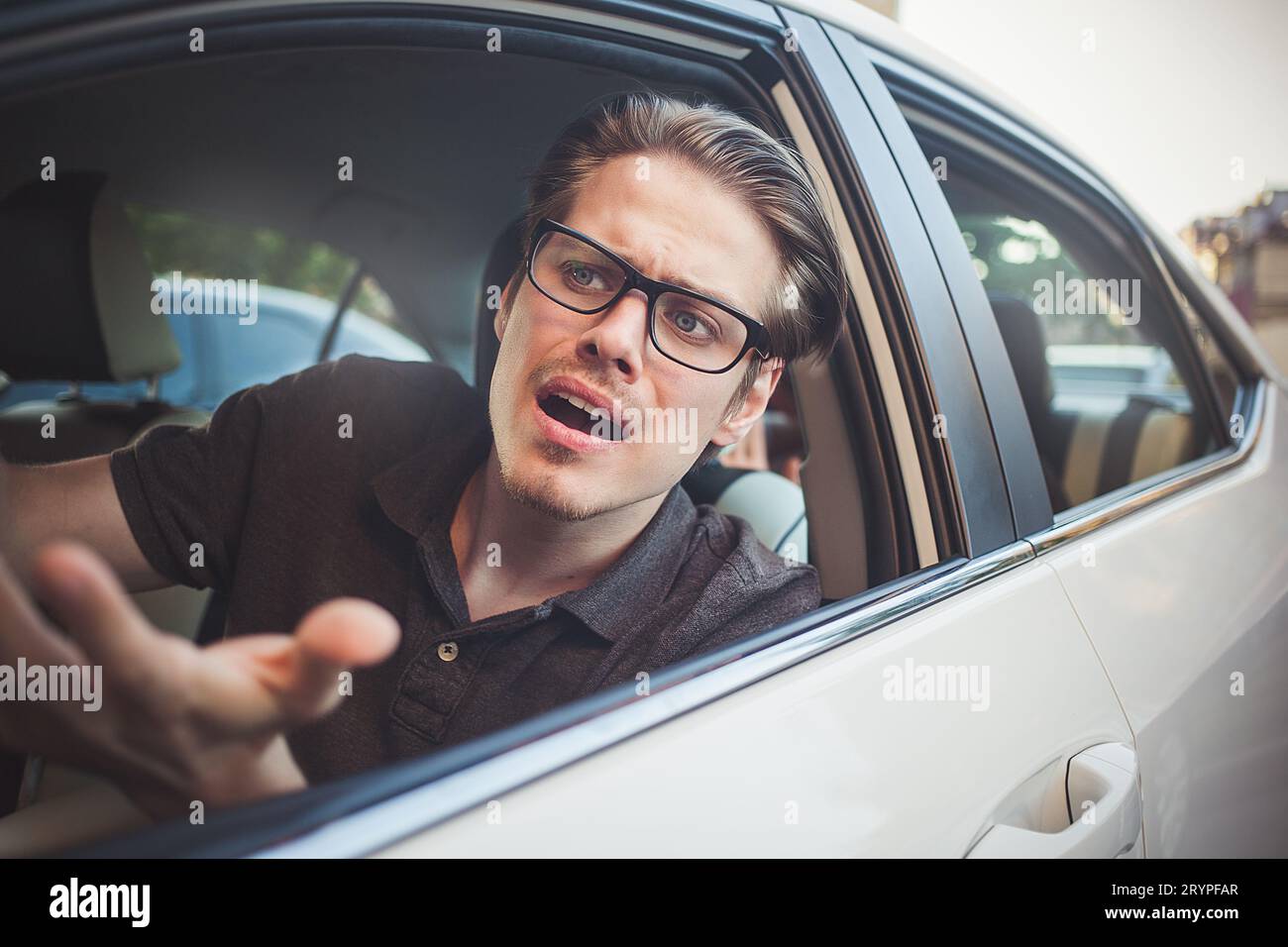 Young man driving a car shocked about to have traffic accident, windshield view. Stock Photo