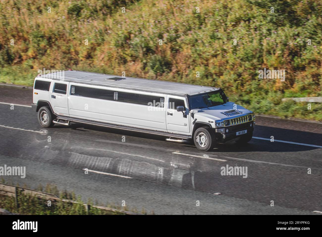 2005 GMC H2 Petrol 6000 cc  White stretched limousine travelling at speed on the M6 motorway in Greater Manchester, UK Stock Photo