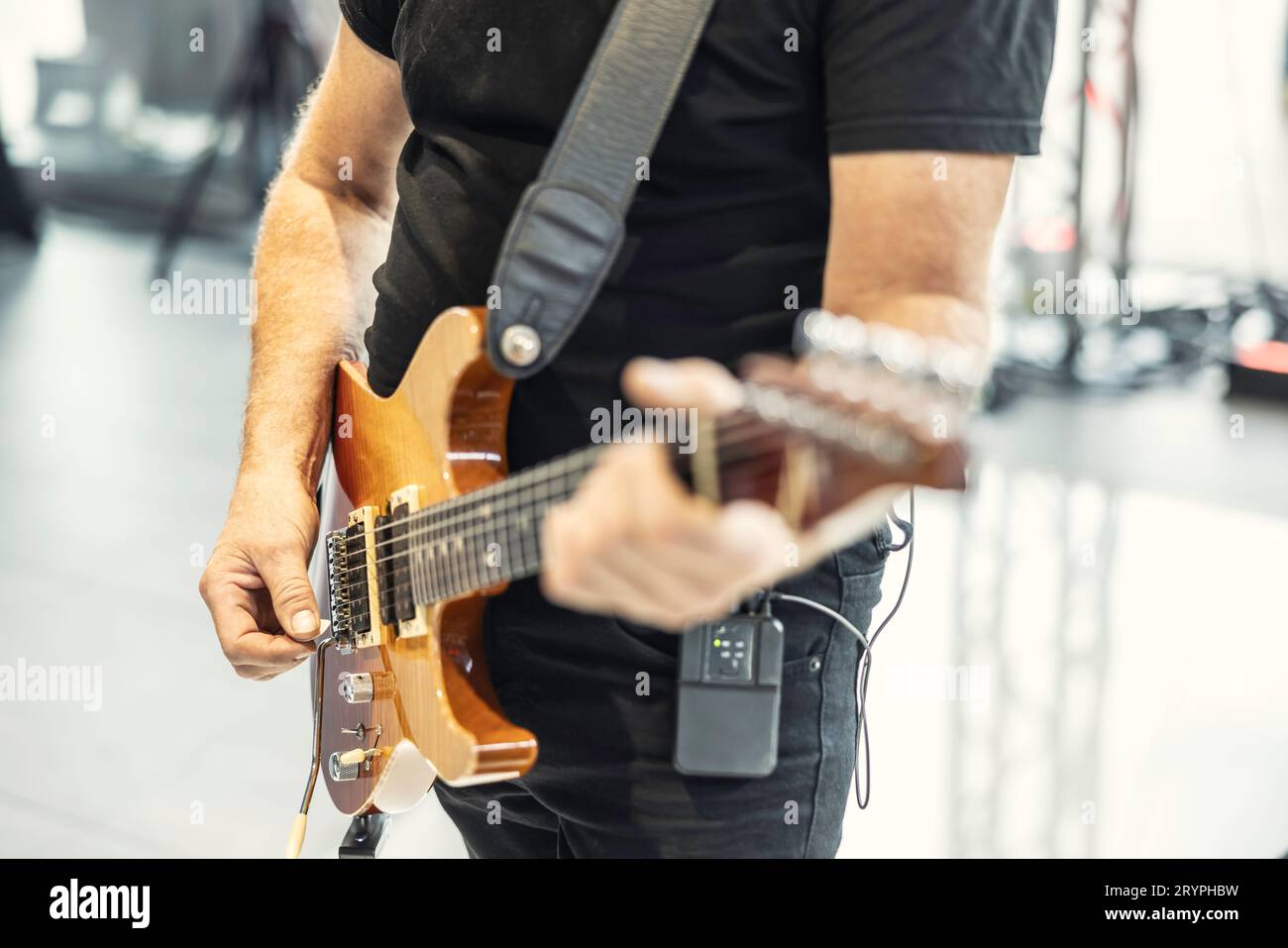 Guitarists play at a rock or rock n roll concert. A guitarist plays chords on an electric guitar. Stock Photo