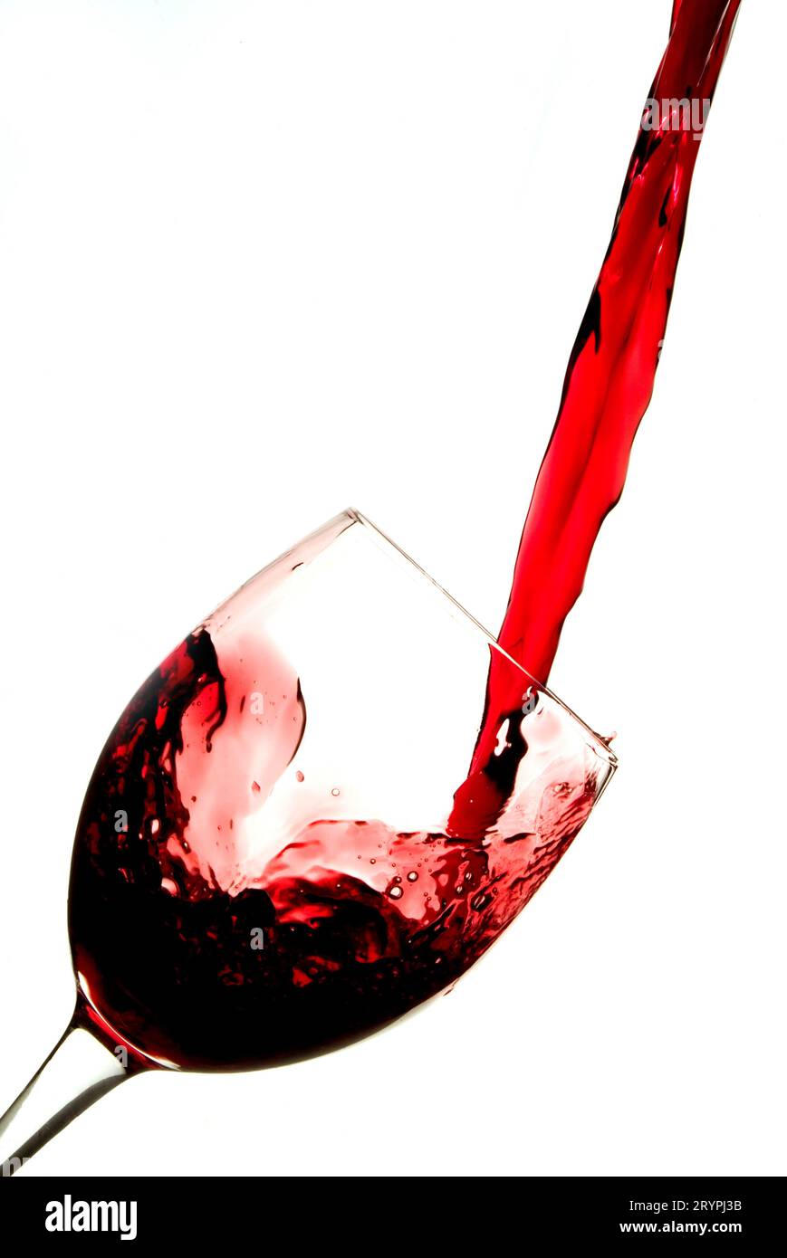 Red wine splashing into a tilted wine glass Stock Photo Alamy