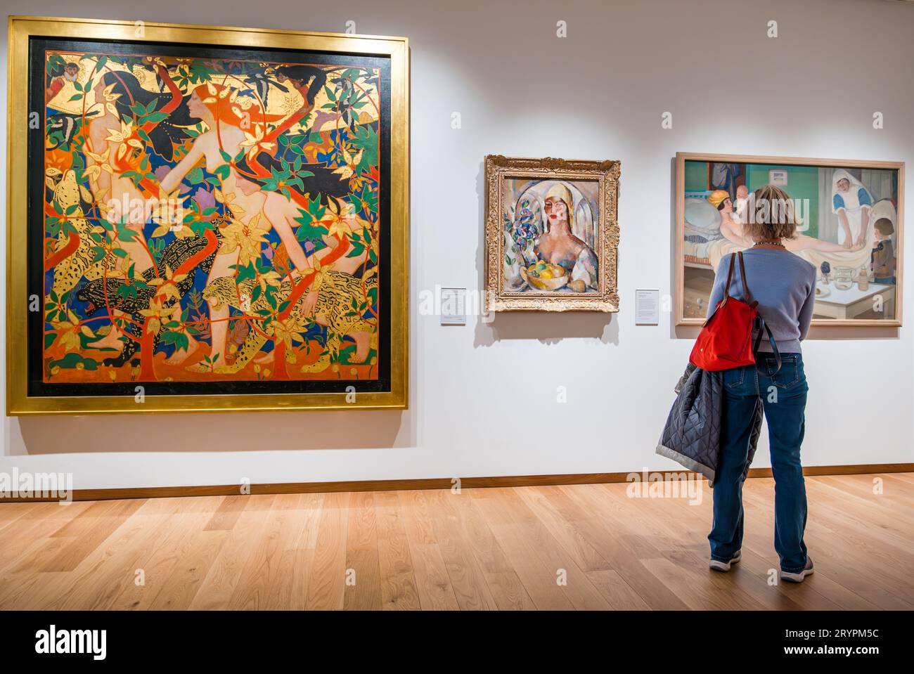 A visitor admiring modernist paintings including artwork The Hunt by Robert Burns at National Galleries of Scotland new extension, Edinburgh, UK Stock Photo