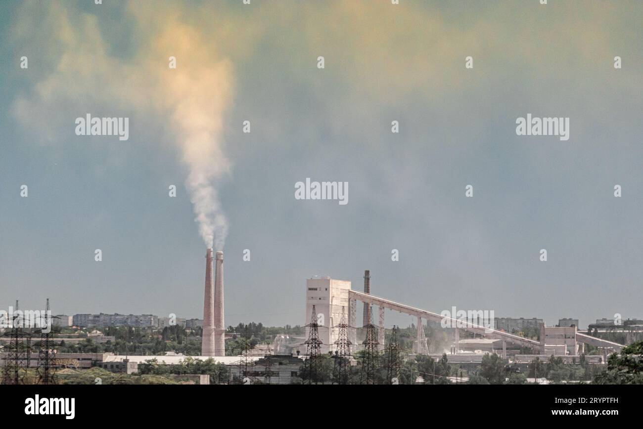 Industrial landscape smoke from the chimney of the plant and smog in the sky over the city in Ukraine Donbass Stock Photo