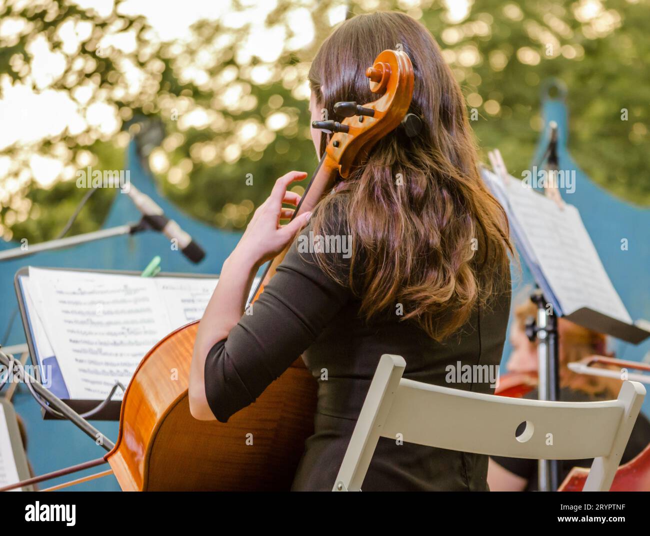 Young brunette girl playing the cello on the street Stock Photo