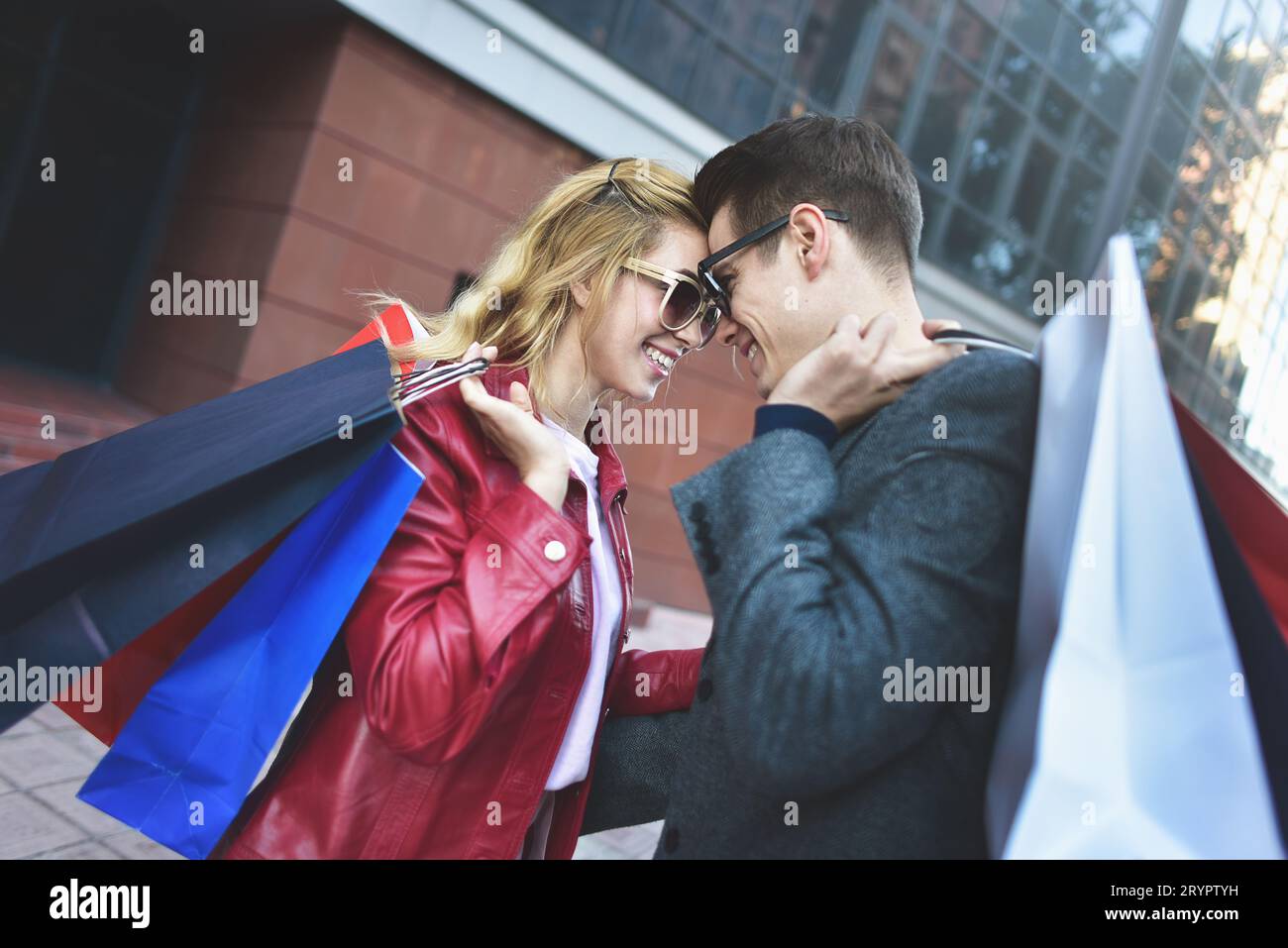 Beautiful young loving couple carrying shopping bags and enjoying together. Picture showing young couple shopping in the city. Stock Photo