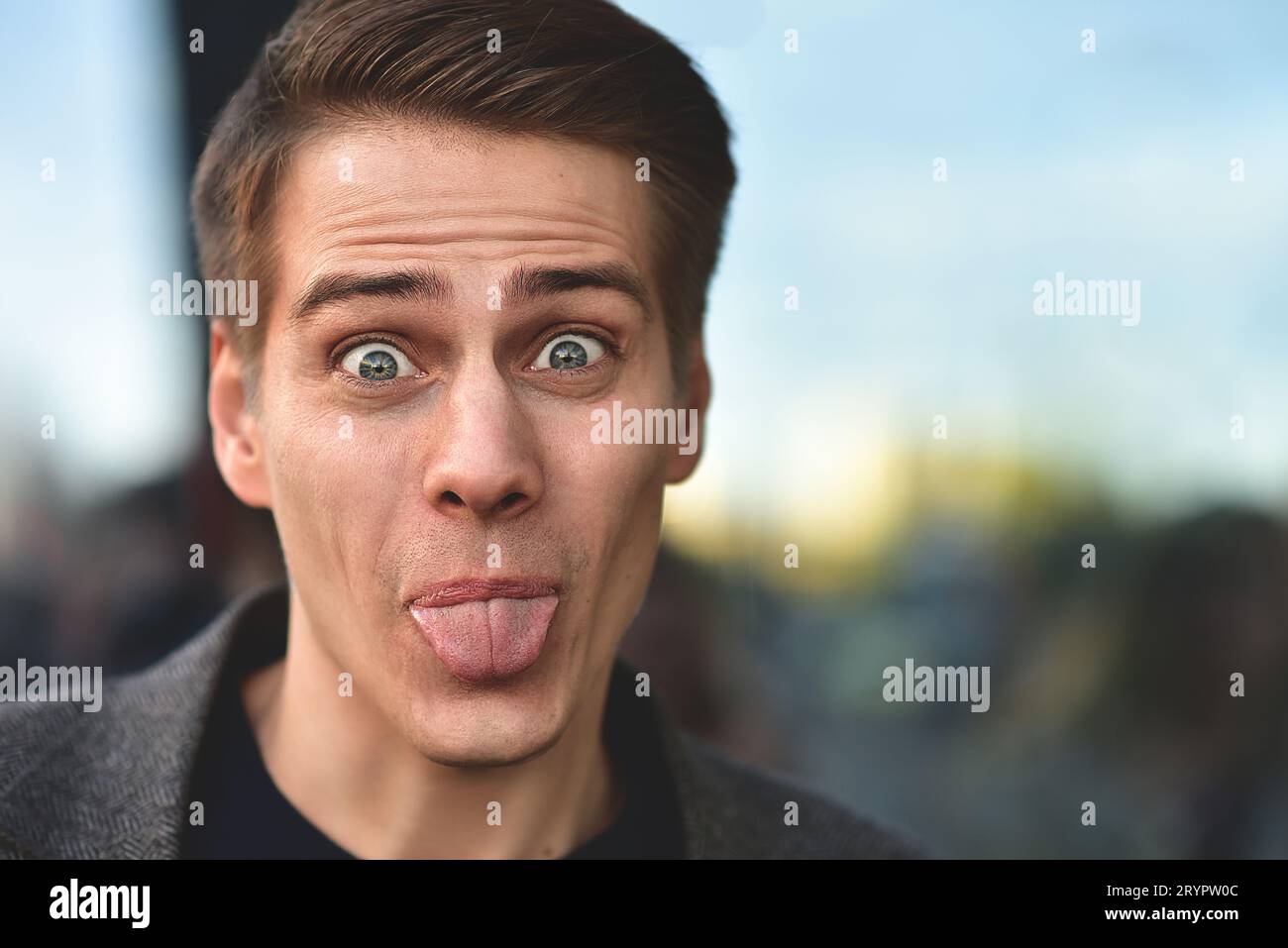 Portrait of stylish happy handsome young man standing outdoors. Stock Photo