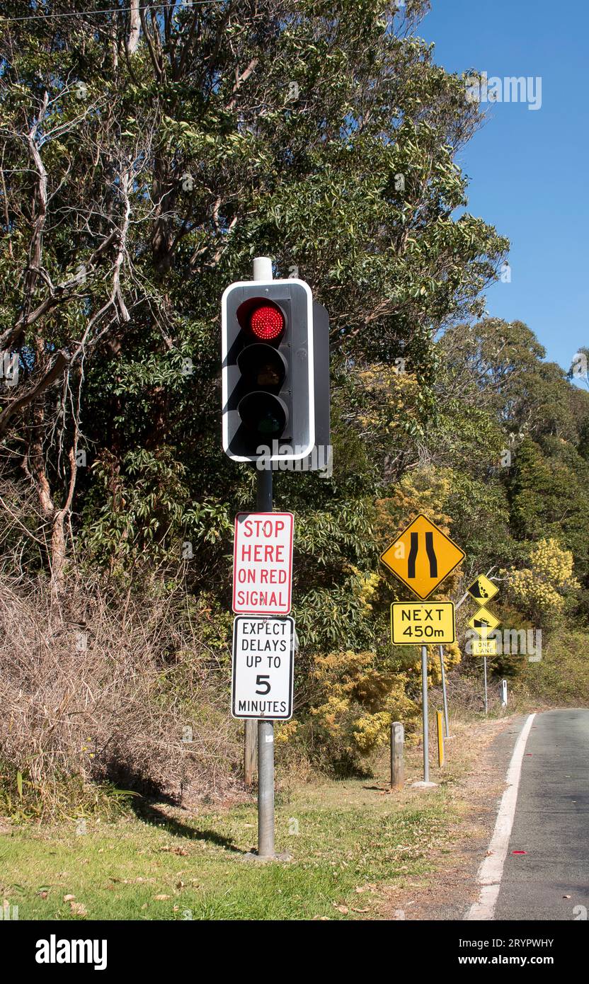 Top of The Goat Track, on Tamborine Mountain, Australia. Road signs and traffic lights for narrow, single lane, warnings of steep road , rock falls. Stock Photo
