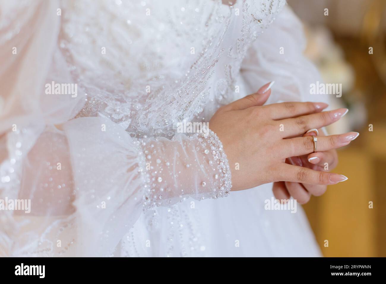 A woman delicately placing a sparkling wedding ring onto the finger of