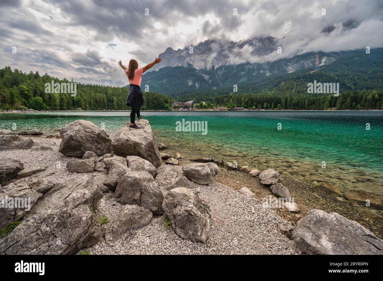 Zugspitze Peak top of Germany Alps mountain range and Eibsee Lake with woman tourist, Garmisch Parte Stock Photo