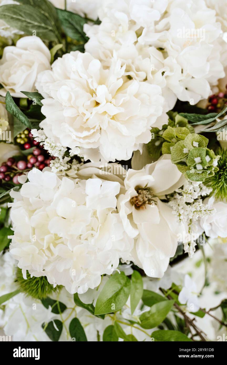 A vibrant and lush close-up of a collection of assorted flowers and lush foliages in a bouquet Stock Photo