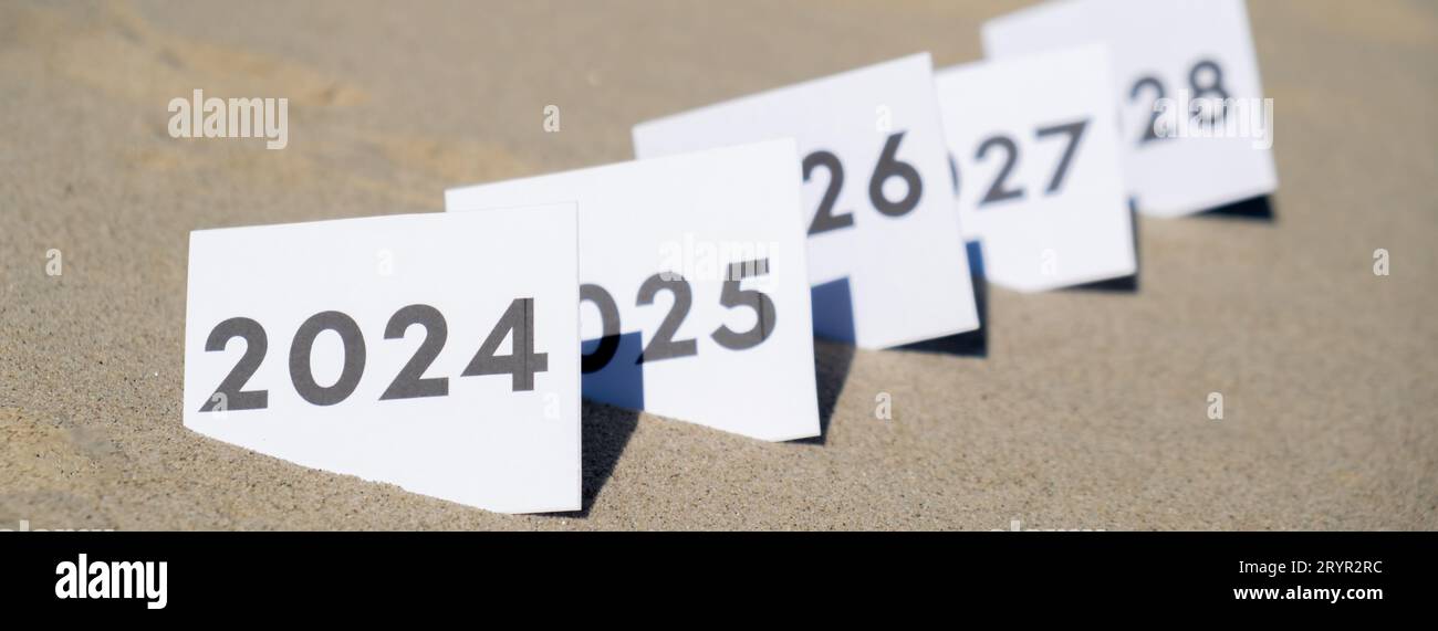 Paper cards with numbers of years from 2024 to 2028 in a row. New year start concept. Resolution time is flying plan goal motiva Stock Photo