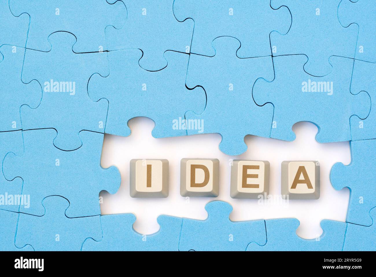 IDEA message on the computer keyboard keys placed among blue puzzle Stock Photo