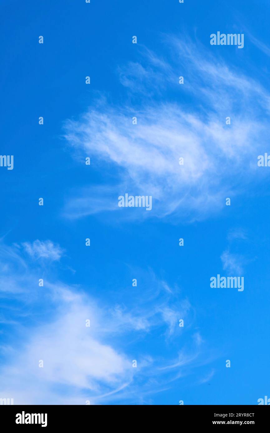 Feathery White Clouds Flowing on Vibrant Blue Sky Stock Photo