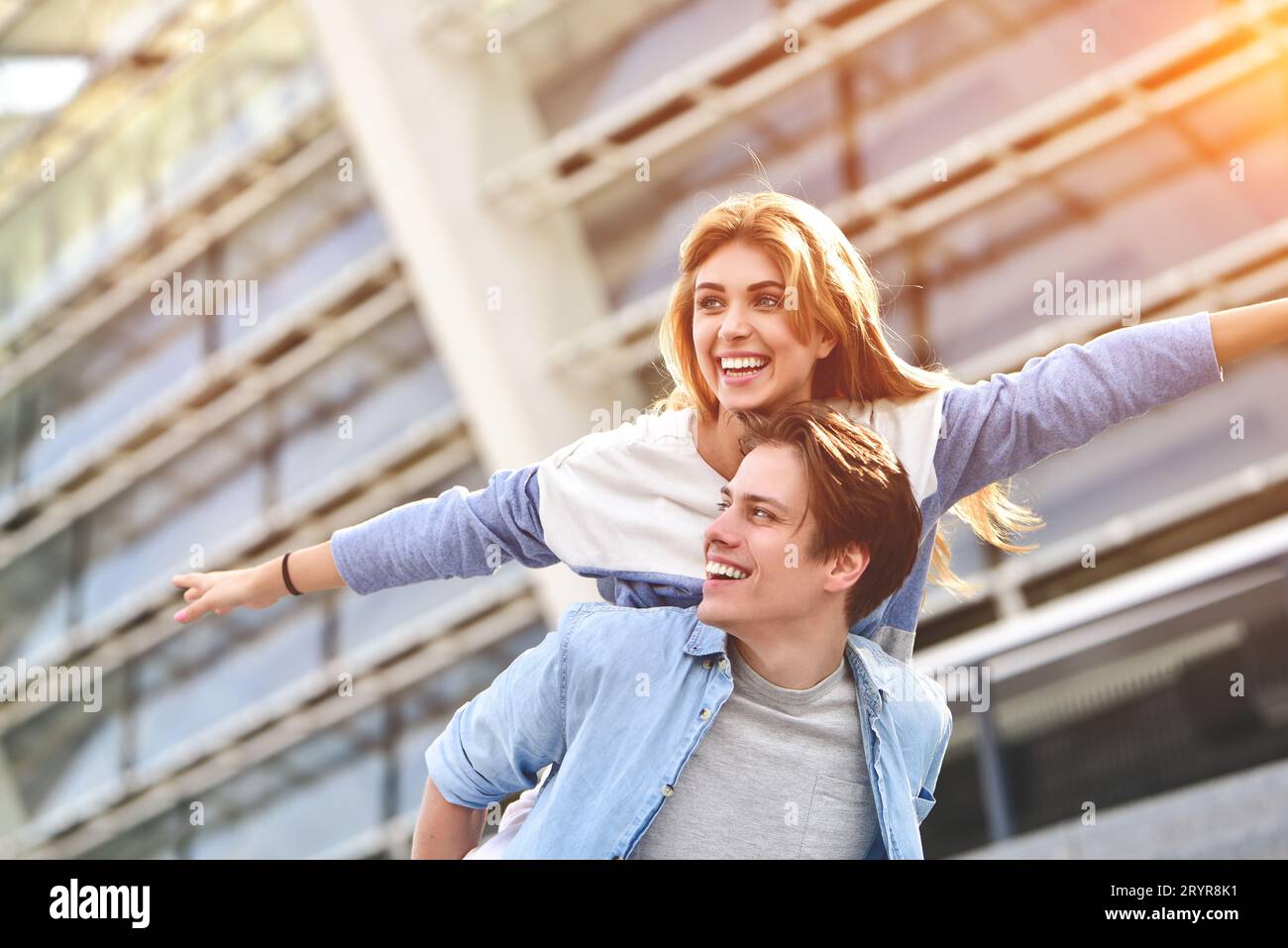 Happy young caucasian couple having fun with piggyback outdoors Stock ...