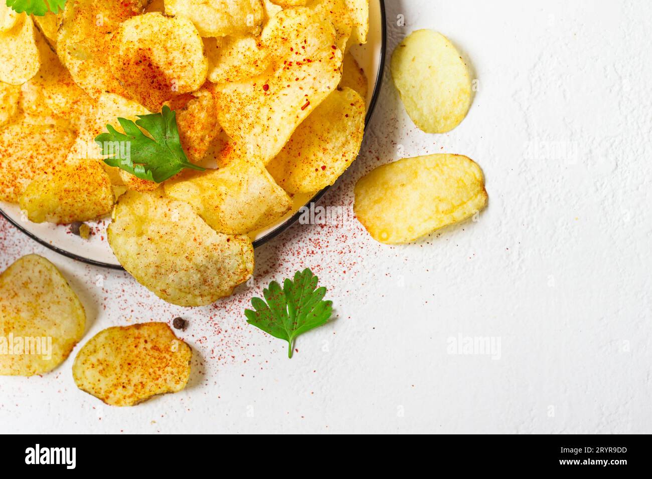 Crispy potato chips on a plate on a white background Stock Photo