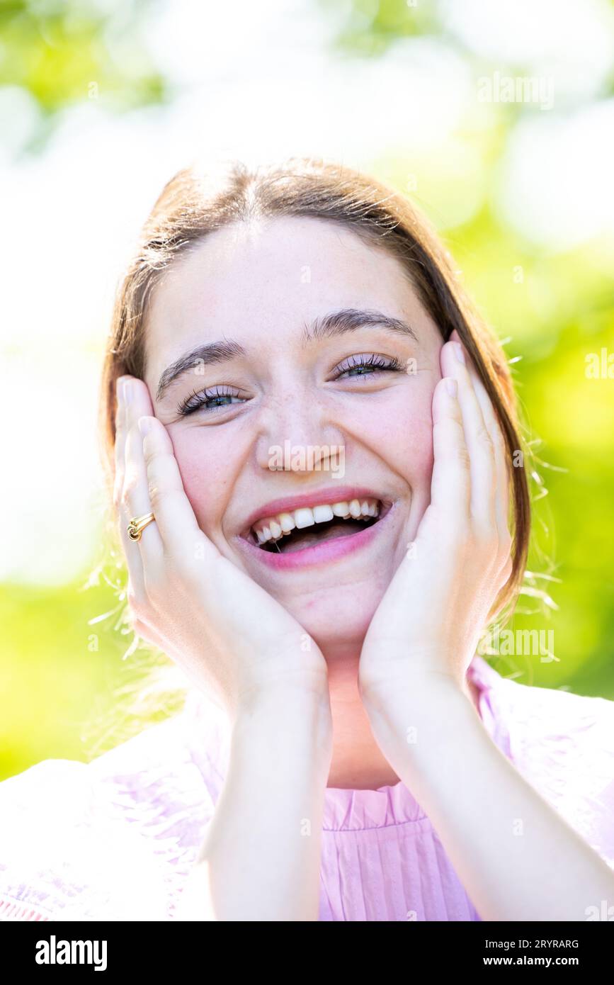 A happy laughing young woman with perfect skin, natural make-up and a beautiful smile. Lifestyle concept showing positive emotio Stock Photo