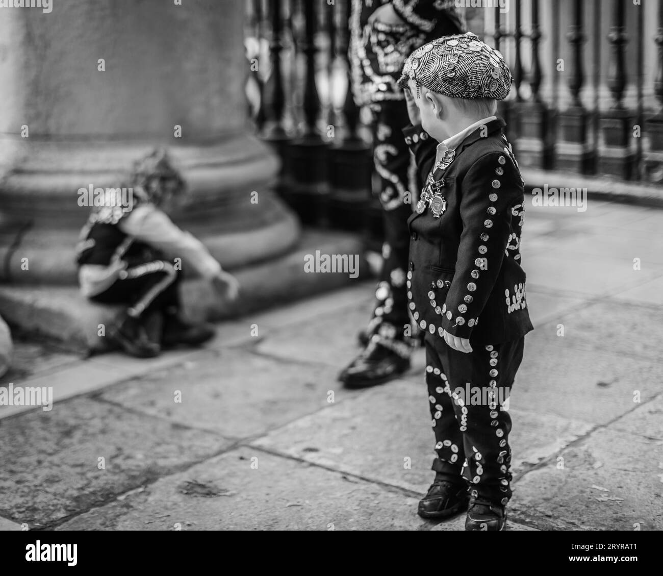 A young Pearly Prince watches over his siblings at St. Martin-in-the-Fields church in London. Stock Photo