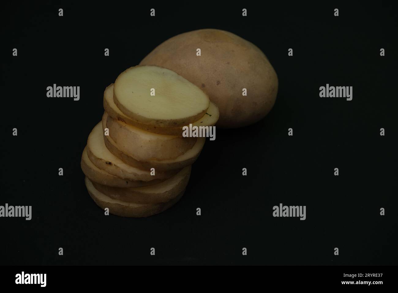 stacked  potato slices on black background. close up view Stock Photo