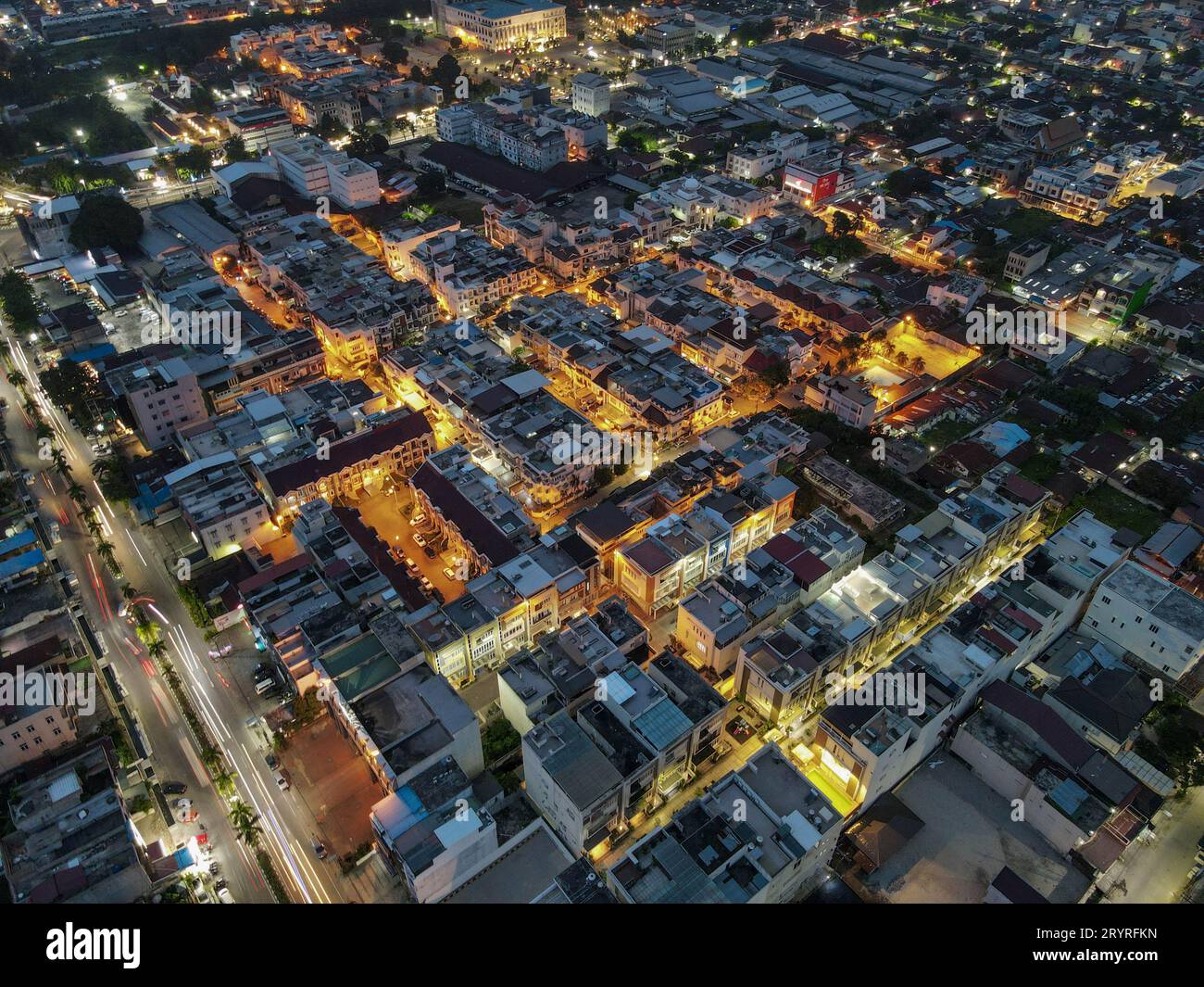 A night view of a busy city at nighttime with glowing lights and buildings. Stock Photo