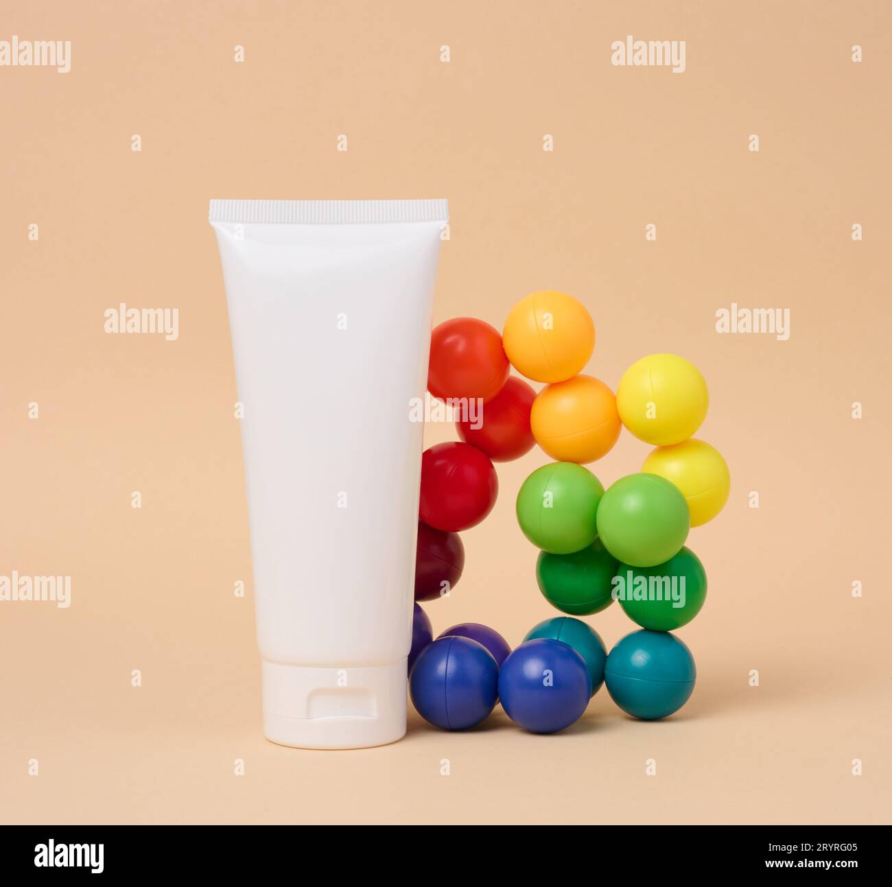 White plastic tube for cosmetics on a beige background. Template for branding, advertising and product promotion Stock Photo