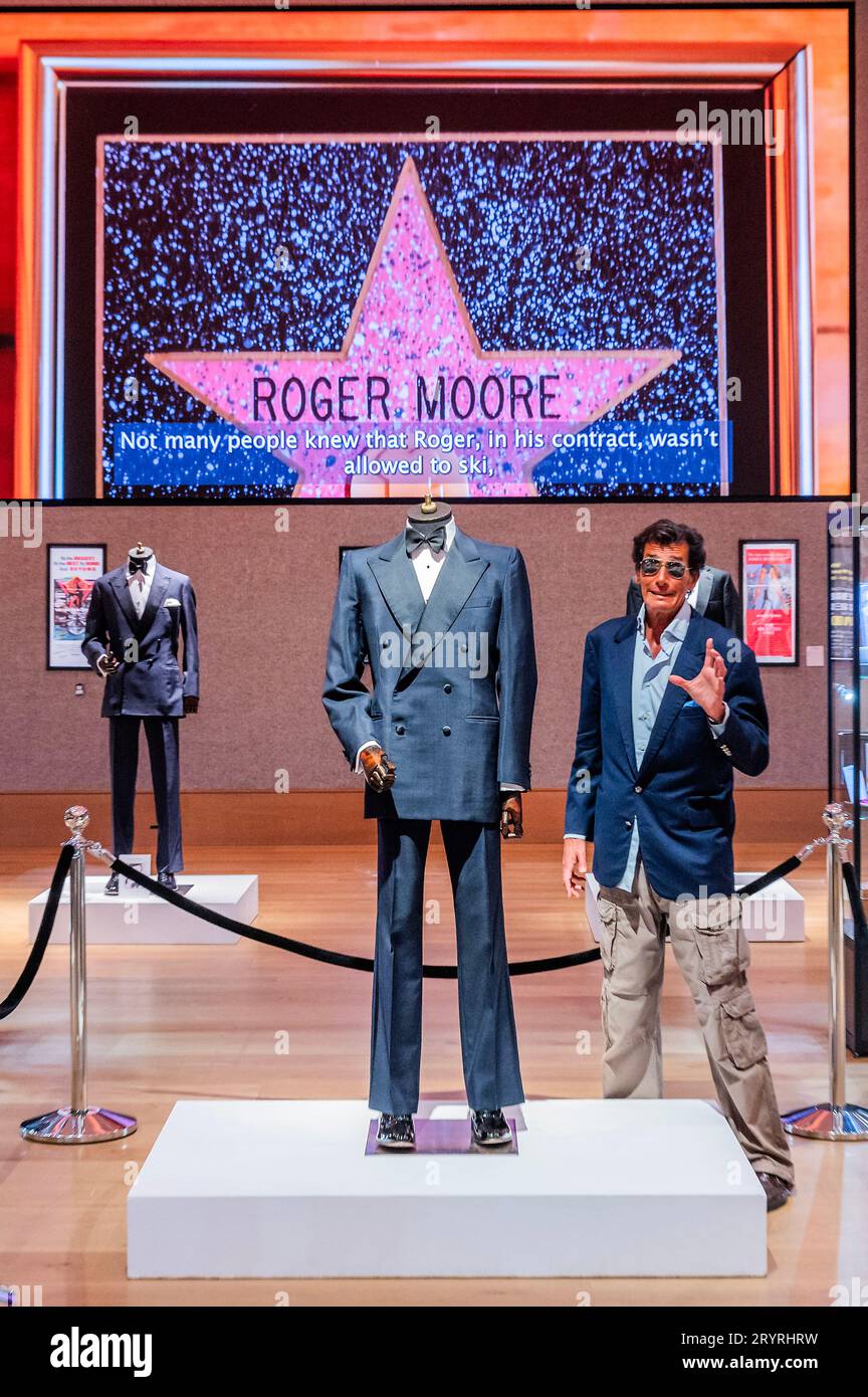 London, UK. 2nd Oct, 2023. Geoffrey Moore (his son) with A Douglas Hayward double-breasted mohair dinner suit made for Sir Roger Moore in A View To A Kill, 1985, est £20,000 - £30,000 with anothert reputedly by Angelo Roma and believed to have been made for Sir Roger Moore in The Spy Who Loved Me, 1977, est £20,000 - £30,000 - Sir Roger Moore: The Personal Collection at Bonhams New Bond Street, London. On 4 October, 180 lots will be auctioned, marking the 50th anniversary year of his first appearance as 007. Credit: Guy Bell/Alamy Live News Stock Photo