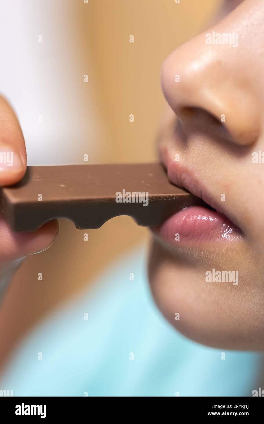 Detailed shot of a girl bites a chocolate bar. Stock Photo