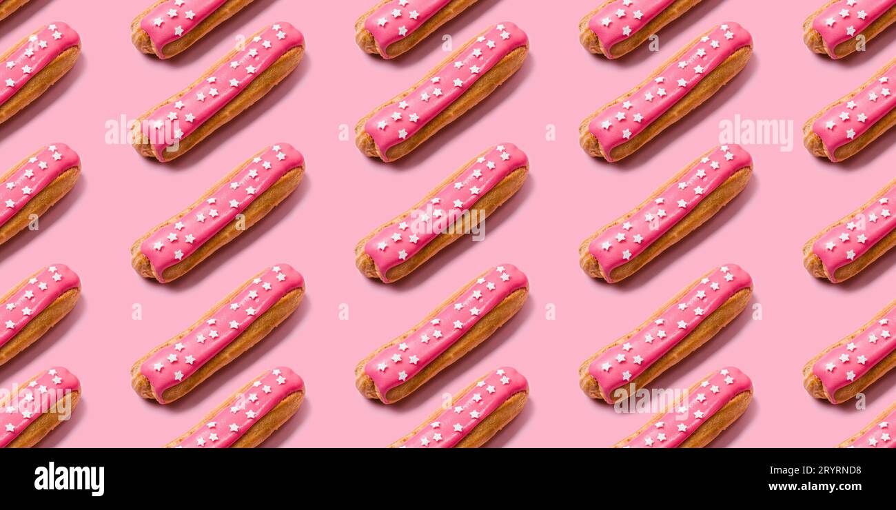 Seamless food creative texture or background. Eclairs pattern with pink icing and stars sprinkled on pink background Stock Photo