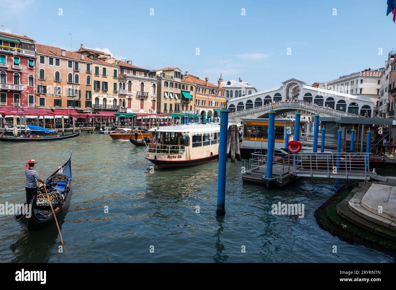 A gondolier steers his gondola into the Grand Canal close to the Rialto Bridge in Venice in the Veneto region of northern Italy Stock Photo