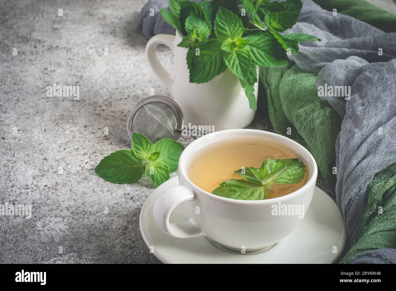 Natural mint tea and fresh mint leaves on a gray background Stock Photo