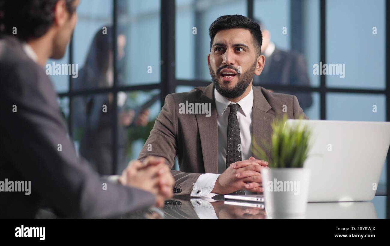 Two medium focused business workers communicate in the office. Stock Photo