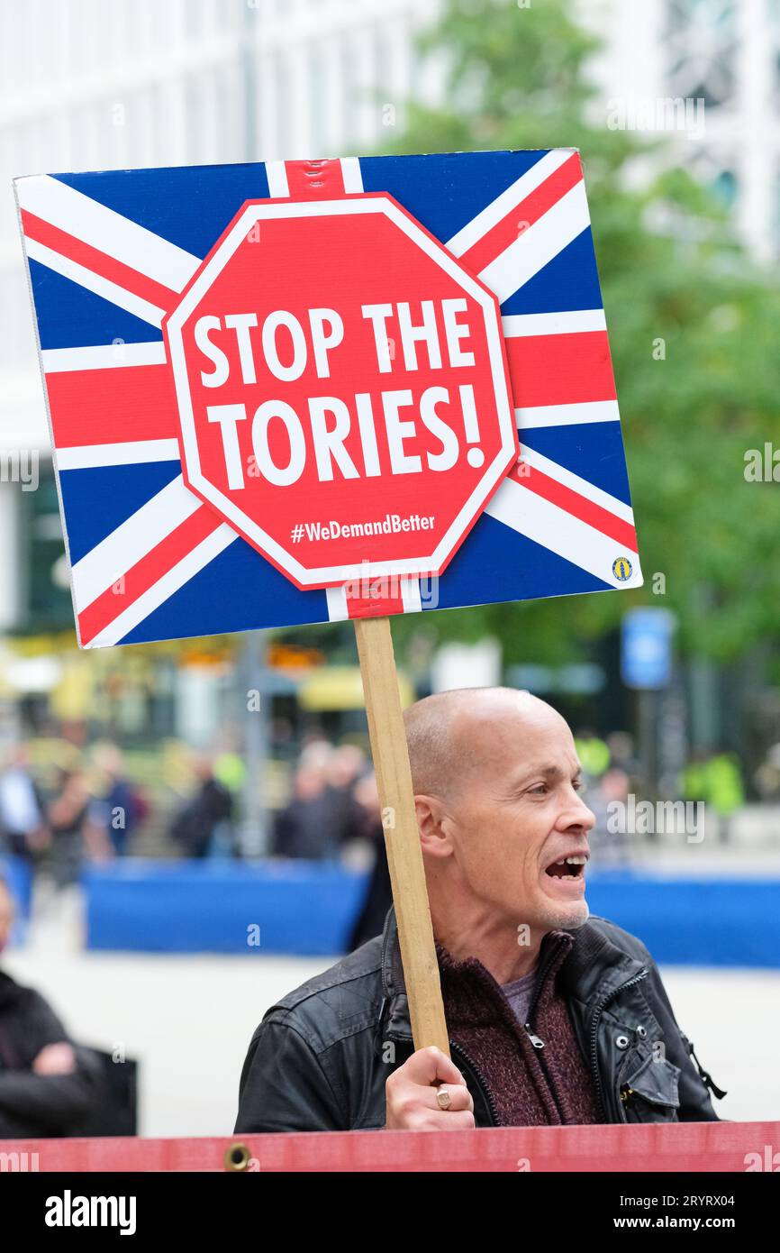 Manchester, UK - Monday 2nd October 2023 – A protester outside the Conservative Party Conference with a 'Stop the Tories' placard - Photo Steven May / Alamy Live News Stock Photo