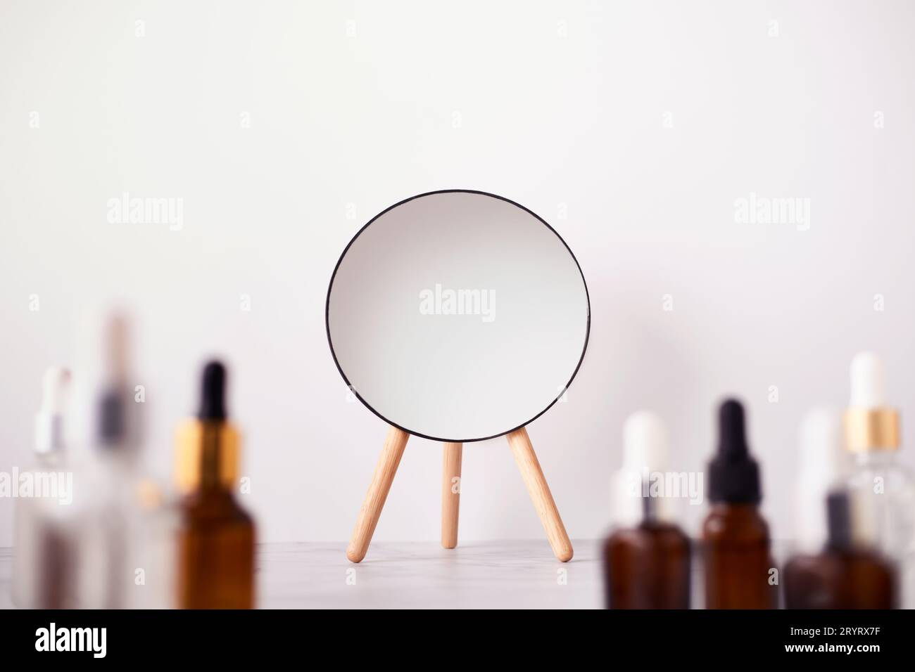 Serum or Liquid Collagen Bottles and mirror on marble table. Anti age beauty Cosmetics products concept, selective focus Stock Photo