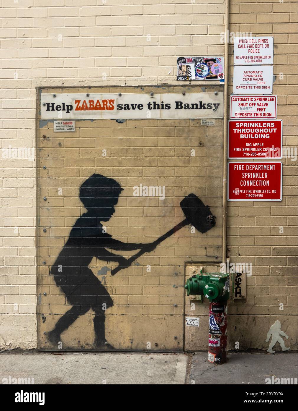 Boy with Hammer by Banksy on a wall near Zabars store in Manhattan NYC Stock Photo
