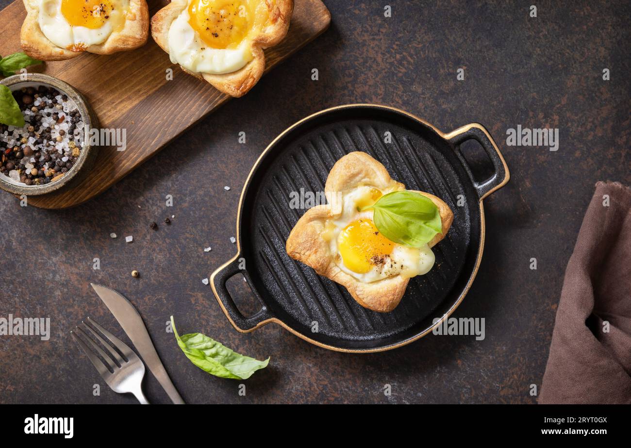 Breakfast idea. Scrambled eggs in puff pastry with cheese and bacon on