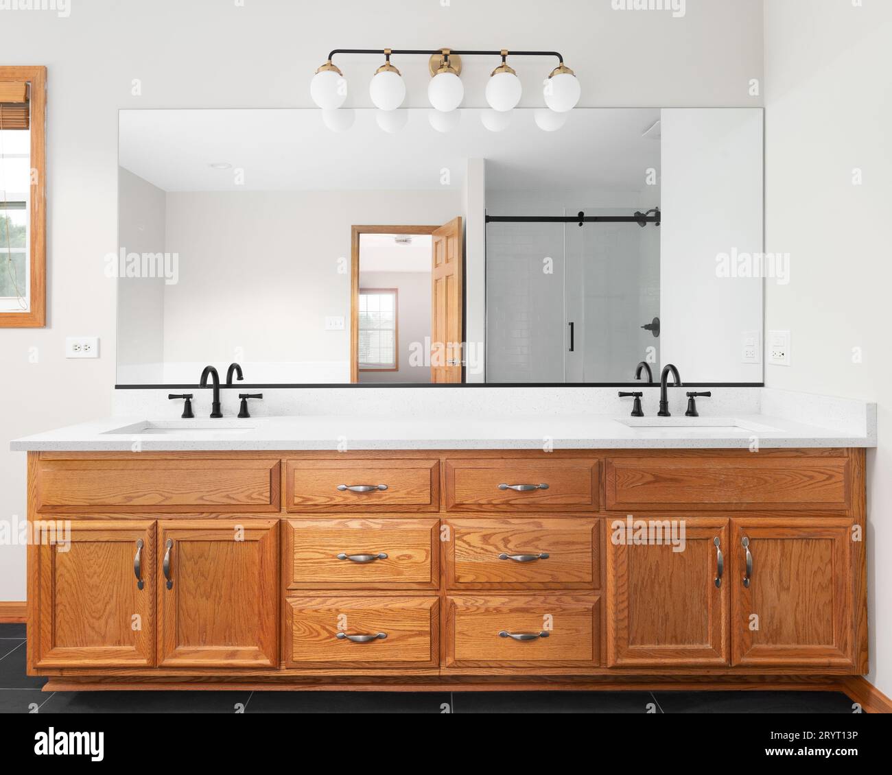 A bathroom detail with a wood vanity cabinet, white marble countertop ...