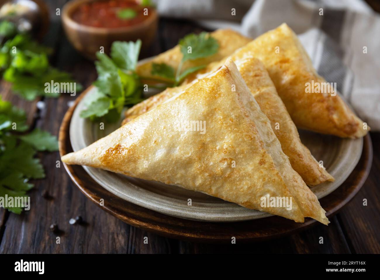 Asian food. Vegetarian samsa (samosas) with tomato sauce on a wooden table. Popular in Indonesia as Risoles Sayur. Stock Photo