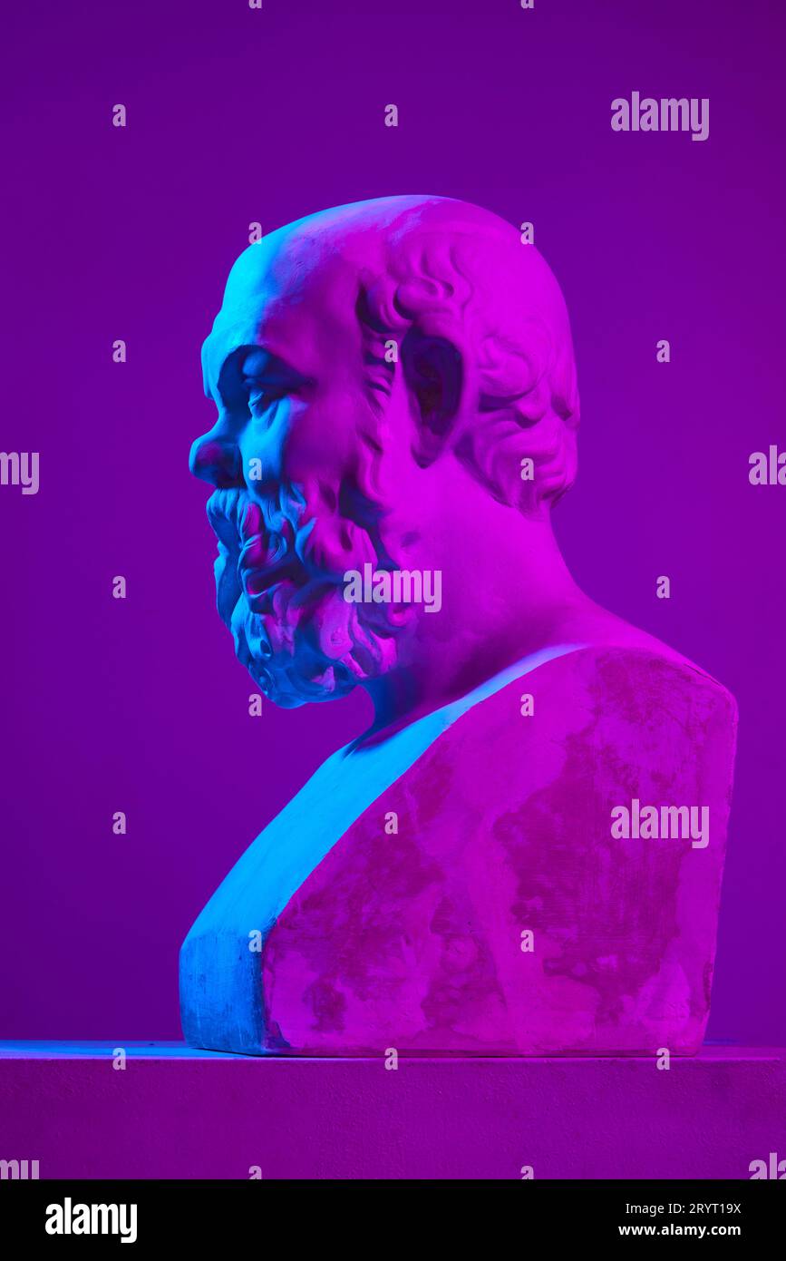 Antique statue bust of man against purple studio background in neon