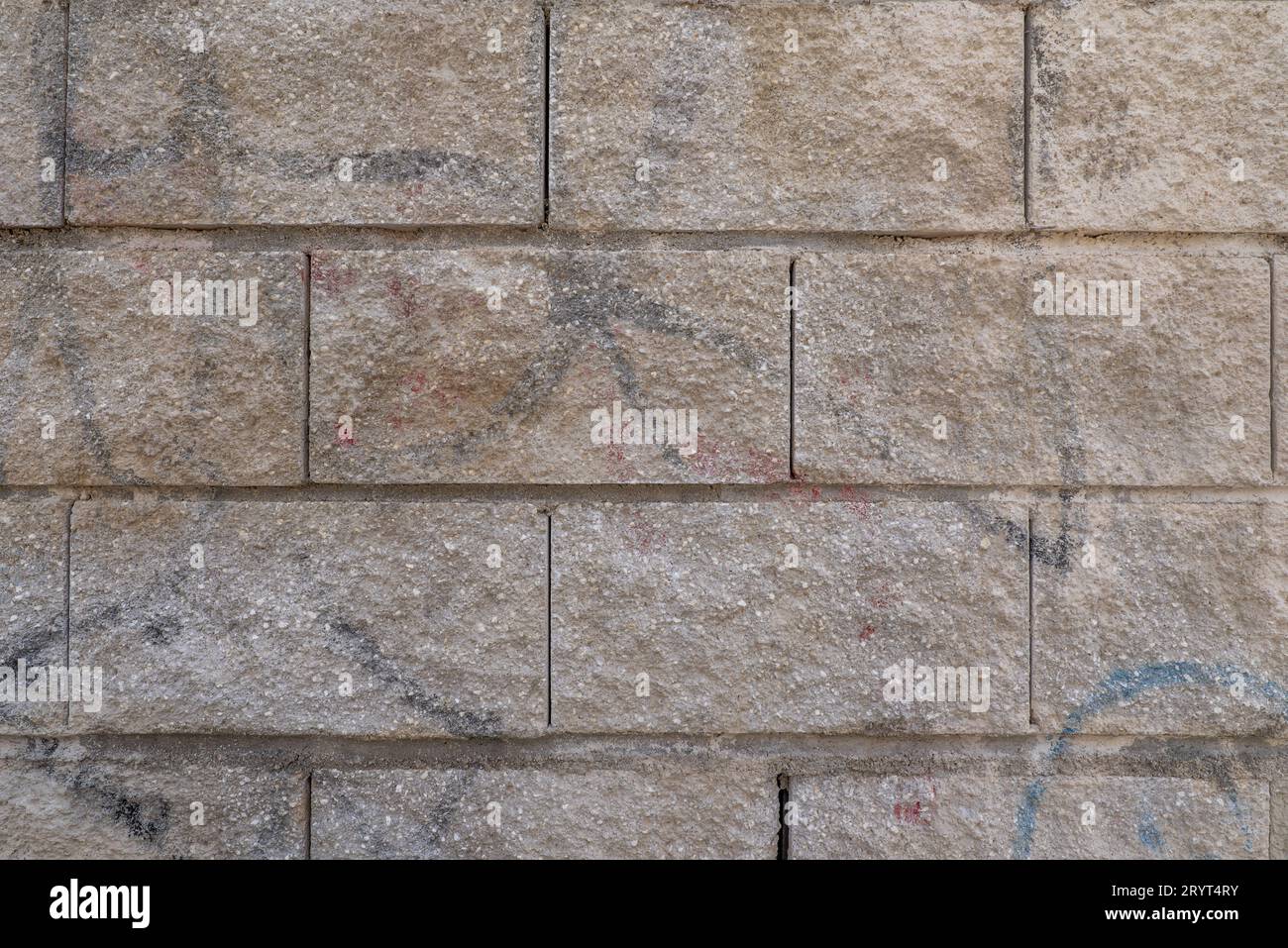 A wall of granite stones held together with cement between the joints